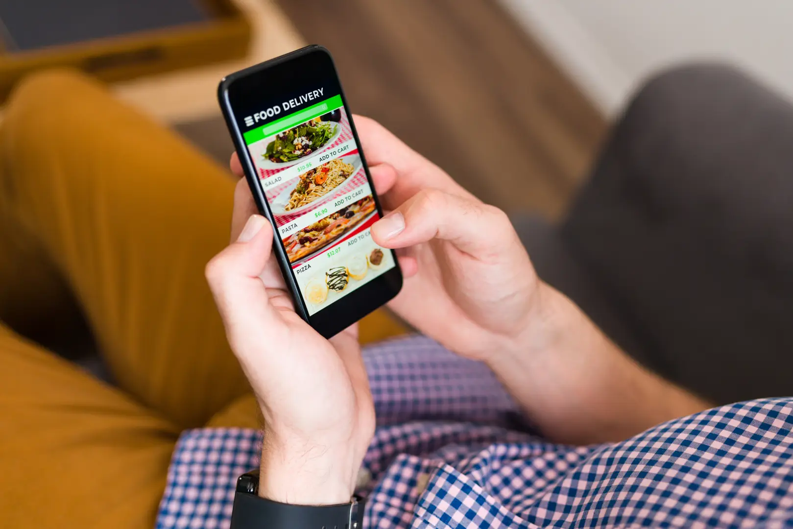 Guest using a smartphone to order food from your phone through a digital room service platform in a hotel
